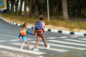 Big Brother Holding Sister Crossing the Road